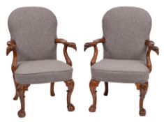 A pair of carved walnut open armchairs in the early 18th Century manner:,