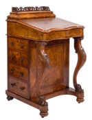A Victorian walnut serpentine fronted davenport:,