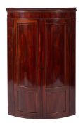 An early 19th Century mahogany and inlaid bow-fronted hanging corner cupboard:,