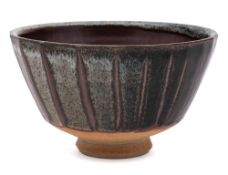 *John Leach [1939] a stoneware bowl: of footed cut-sided form decorated with oatmeal over tenmoku