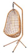 A late 20th Century bamboo swing chair on stand: the 'egg' shaped seat suspended from a bamboo