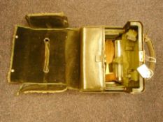 An Edwardian green leather vanity case: the fitted interior with silver gilt topped glass bottles