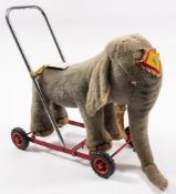 A mid 20th century Merrythought 'Shilpa' plush Indian elephant on wheels,