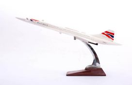 A desk top model Concorde: in British Airways livery,mounted on a chrome and wood stand, 42cm long.
