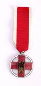 A Second World War German Red Cross Medal: central black enamelled eagle on a red enamel cross,