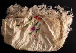 A Chinese silk shawl: with floral embroidered decoration to an ivory ground, edged with fringe.