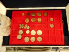 A folder containing a small group of Roman coins,: two Sinking of the Lusitania medallions,