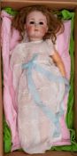 An early 20th century Simon & Halbig bisque head doll: applied brown wig over glass eyes (loose in