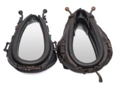 Two black leather and brass horse collar mirrors: height of largest 70cm (2).