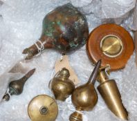 Three steel tipped brass plumb bobs: one with brass reel and line,