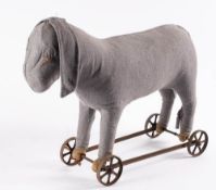 An early 20th century donkey on wheels: ( worn) together with a later blonde plush toy dog on
