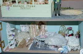 A 20th Century doll's shop 'Bridal Fayre' with green house cake shop above, together with figures,