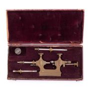 A vintage French watchmaker's brass Jacot tool: in a red leather covered fitted case inscribed