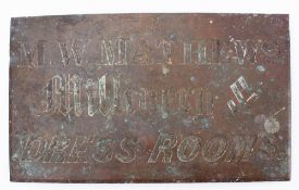A late 19th/early 20th century brass building nameplate for 'M W Mathews Millinery & Dressing