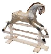 A late 19th/early century painted pine rocking horse: glass eyes, open mouth with teeth,