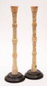 A pair of Japanese turned bone candlesticks: with incised decoration of birds amongst trailing