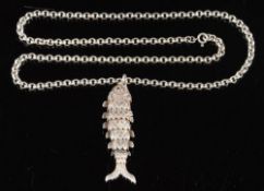 A silver fish pendant,: the articulated silver fish with circular cut garnet eyes,