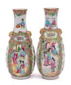 A pair of Chinese Canton famille rose vases: with relief lion-dog ring handles,