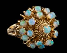 An opal dress ring,: set with a cluster of circular cut opals, stamped 18k, ring size K.