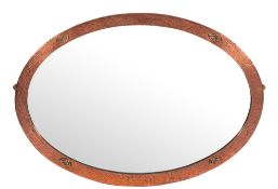 An Arts and Crafts planished copper framed oval wall mirror, circa 1900,