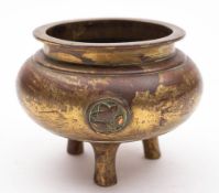 A Chinese bronze and gilt decorated tripod censer: of plain circular form.