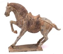 A Chinese pottery figure of a rearing horse in Tang Dynasty style: decorated in grey and red
