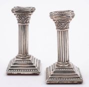 A pair of Edward VII silver miniature Corinthian column candlesticks or tapersticks,