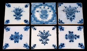 A group of six 18th century English blue and white delftware tiles: floral subjects comprising a