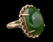 A nephrite ring,: the oval cabochon nephrite in a four claw setting, stamped 18k, ring size J 1/2.