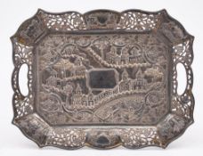 An Oriental silver tray: of rectangular outline with embossed decoration of buildings amongst trees,
