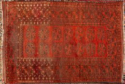 A Turkoman rug:, the brick red field with two rows of serrated quartered octagons,