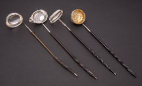 A group of four silver toddy ladles, all unmarked: with baleen spiral twist handles.