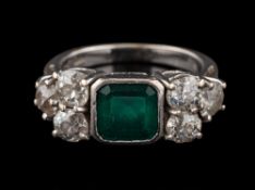 An emerald and diamond ring: the square cut emerald in a collet setting,