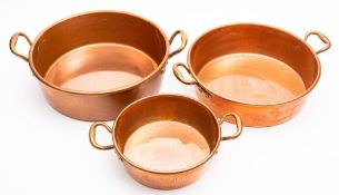 Three 19th century graduated copper preserve pans: of circular outline, with loop carrying handles,