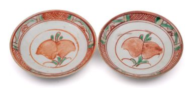 A pair of Chinese swatow saucers: each enamelled in red, green and yellow with a peach spray,