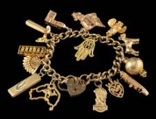 A gold coloured charm bracelet,: the curb link bracelet with various charms,