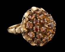 A sunstone dress ring,: set with a cluster of circular cut sunstones, stamped 18k, ring size K.