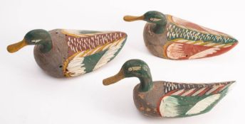 A set of three carved wood decoy ducks: with polychrome decoration, 28cm long.