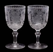 A pair of engraved glass wine goblets: each on knopped stem and engraved with panels of floral