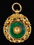 A green hardstone pendant,: the circular green hardstone with a central flower head,