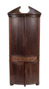 A George III oak bowfront corner cupboard, circa 1775,