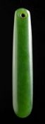 A Maori jade pendant (Kuru): of slender rectangular form with pierced end, 6.5cm long.