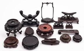 A collection of Chinese carved and plain wood stands: various shapes and sizes.