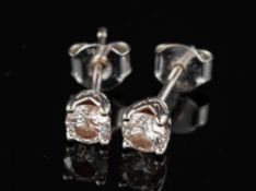 A pair of diamond ear studs,: the brilliant cut diamonds estimated to weigh 0.