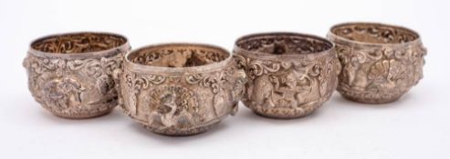 A set of four Burmese silver circular salts: with embossed decoration of animals birds and figures,