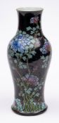 A Chinese famille noire baluster vase: enamelled with flowering peony branches on a black ground,