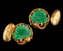 A pair of jade cufflinks,: the carved lotus jade panels within decorative surrounds, 1.7cm diameter.