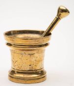 A late 17th century brass pestle and mortar: of cylindrical waisted outline, 13.