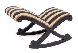 A Regency or George IV ebonised oak rocking gout stool, circa 1820,: with later striped upholstery,