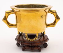 A Chinese bronze censer: of cylindrical form with flat rim and faux bamboo feet and handles,